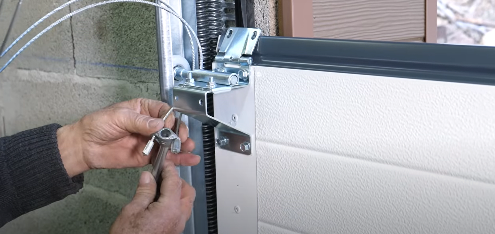 "Technician repairing a noisy garage door to ensure smooth operation and reduced noise levels"v