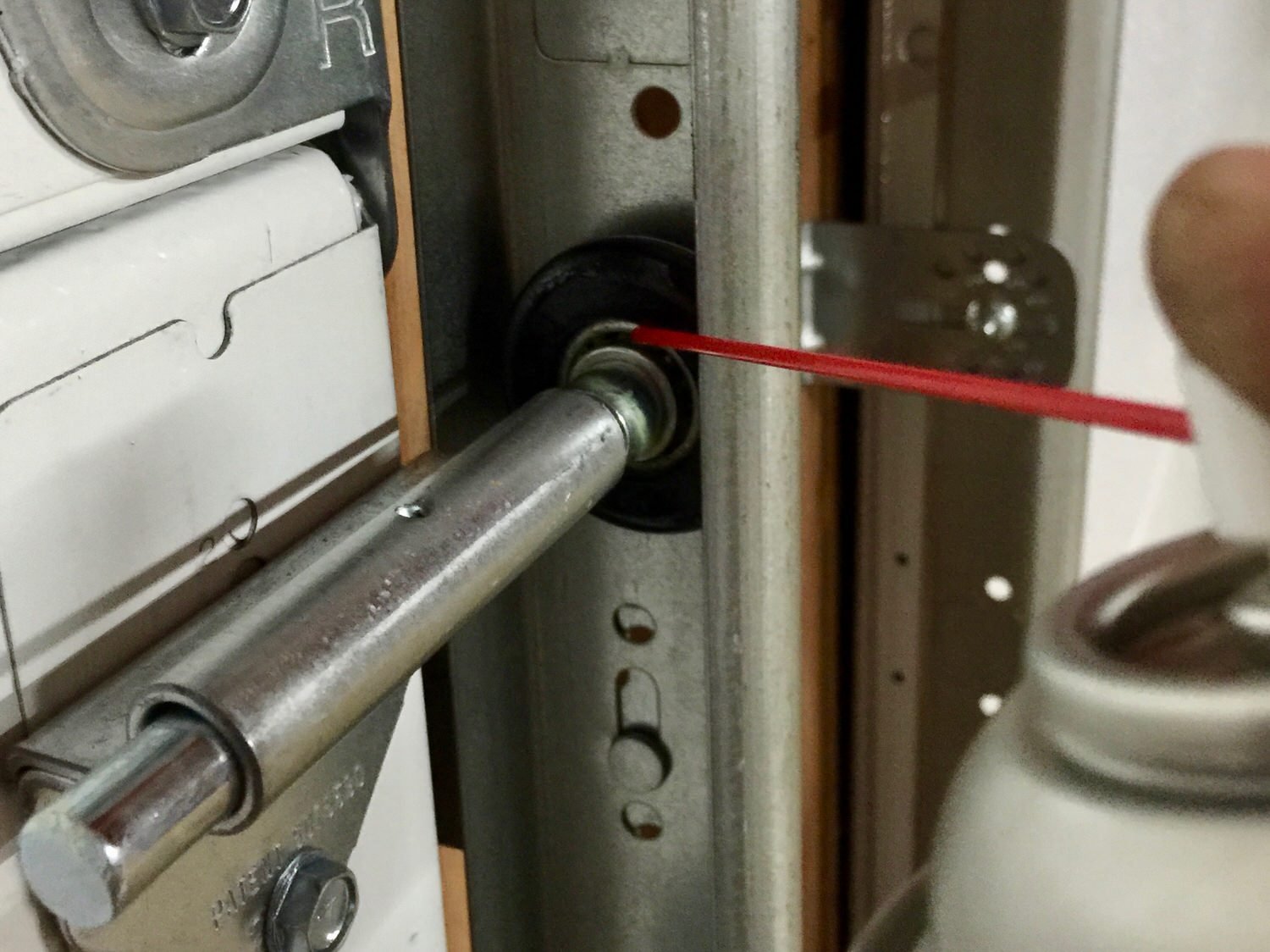"Technician repairing a noisy garage door to ensure smooth operation and reduced noise levels"