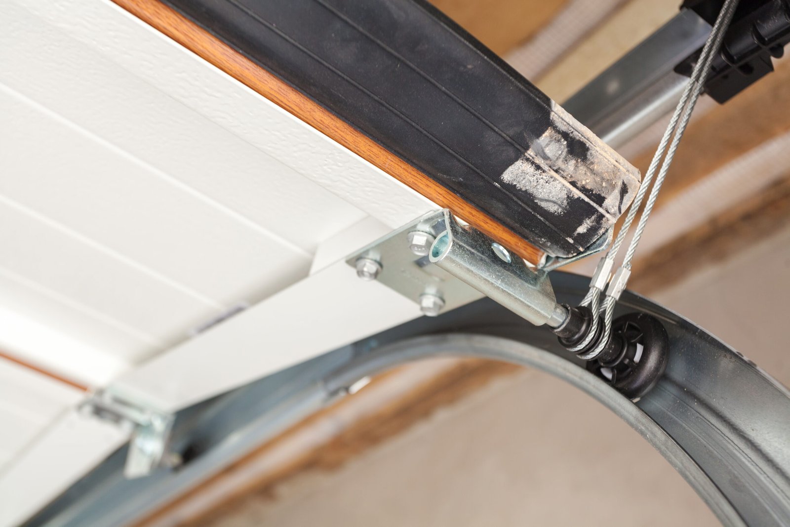 Detailed image of a garage door track repair process to fix door misalignment."
