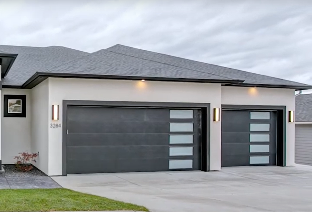 A modern garage door with a dent being inspected for damage.
